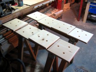 Resting work on sawhorses like this is really precarious,
but I was out of good srufaces and needed the workbench as a
working surface. I've seen some nice clips that fit inside
drilled holes like that, mostly used for finishing cabinet
doors after holes have been drilled for Europena hinges.
I could probably make up some cheap substitutes,
but I like drying things flat.